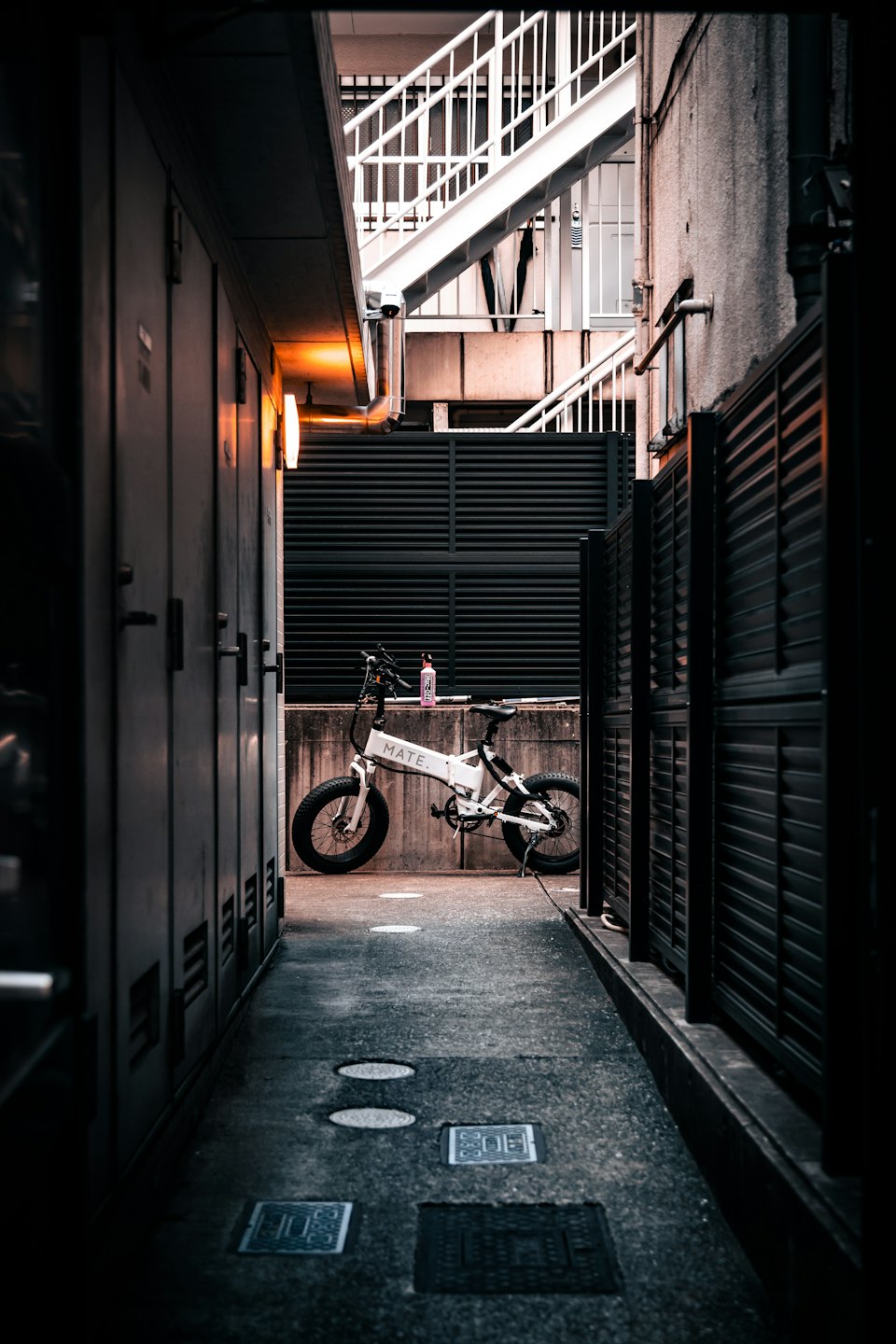 Una bicicletta elettrica bianca con pneumatici spessi parcheggiata contro un muro.