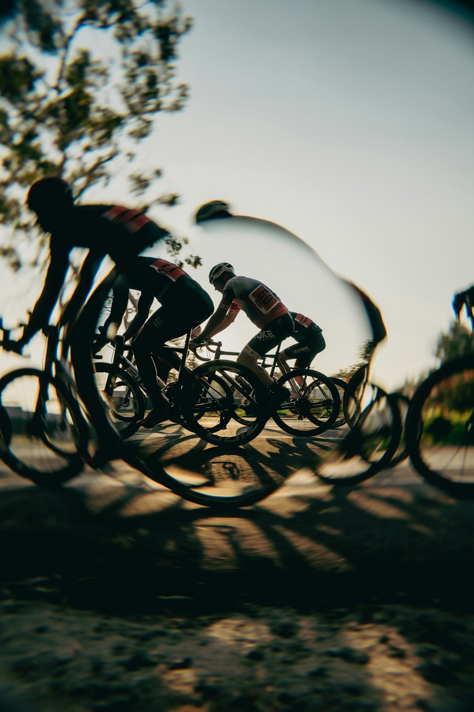 Ciclisti in gara su una strada soleggiata durante l'ora d'oro.