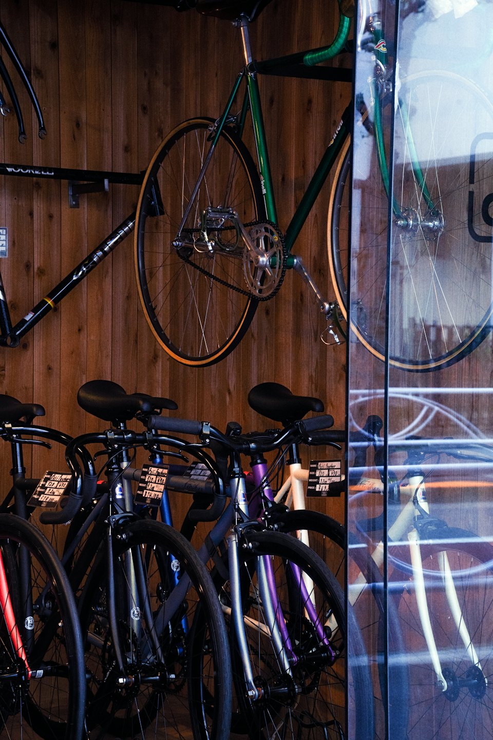 Biciclette moderne e vintage esposte su una parete di legno.